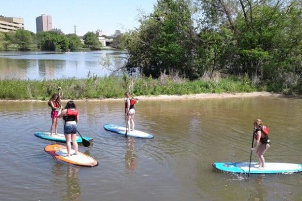 a group of people riding on the back of a boat in the water