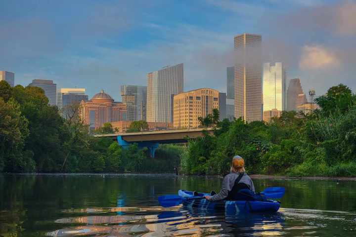 a small boat in a body of water with a city in the background
