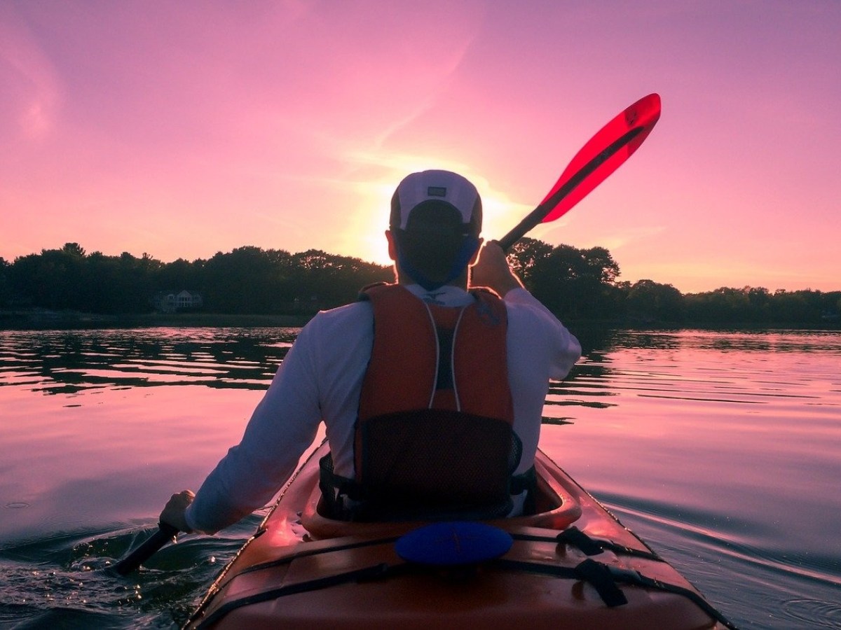 a man sitting in front of a body of water