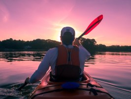 a man sitting in front of a body of water