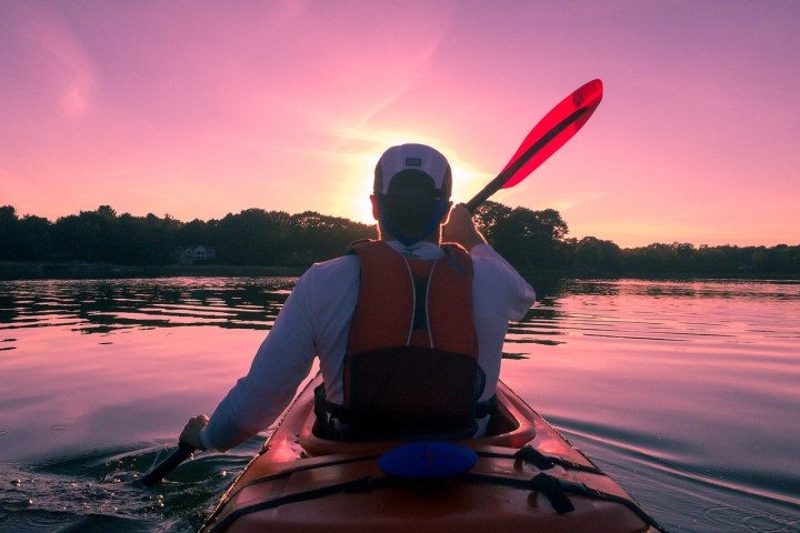 a man sitting in front of a body of water