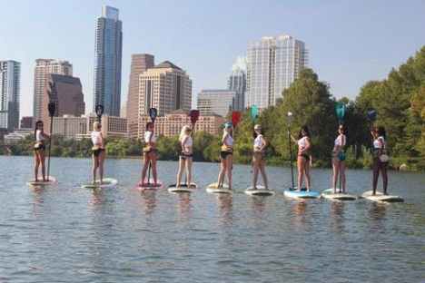 a group of people standing next to a body of water