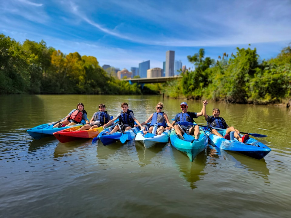 corporate retreat kayaking in buffalo bayou houston texas a group of people in a small boat in a body of water